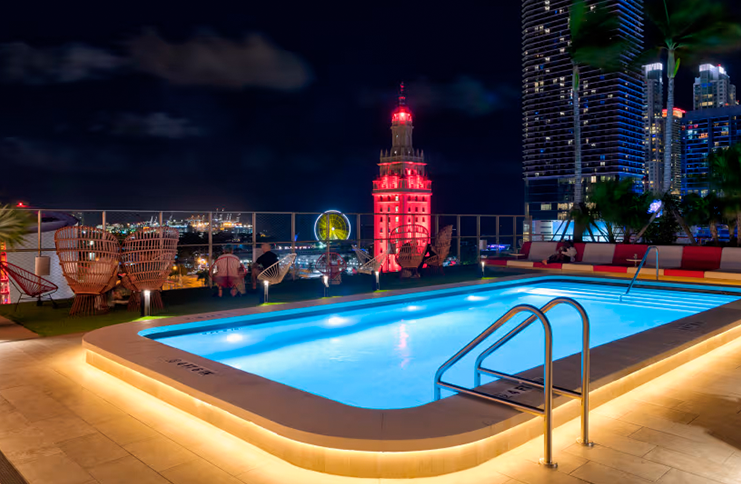 Rooftop pool with waterproof LED strip lighting, creating a stylish ambiance against a vibrant city skyline at night.