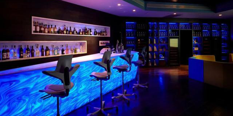Stylish bar with blue illuminated counter and shelves