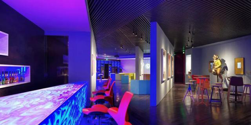 Modern bar and lounge with vibrant lighting and colorful furniture