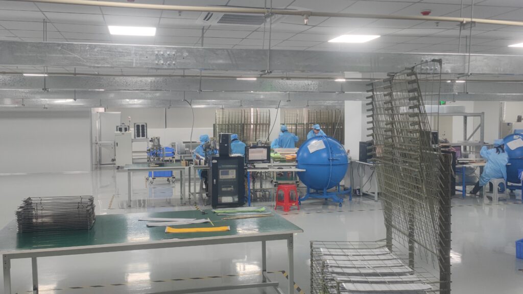 LED strip lights manufacturing cleanroom, workers in blue suits assembling products