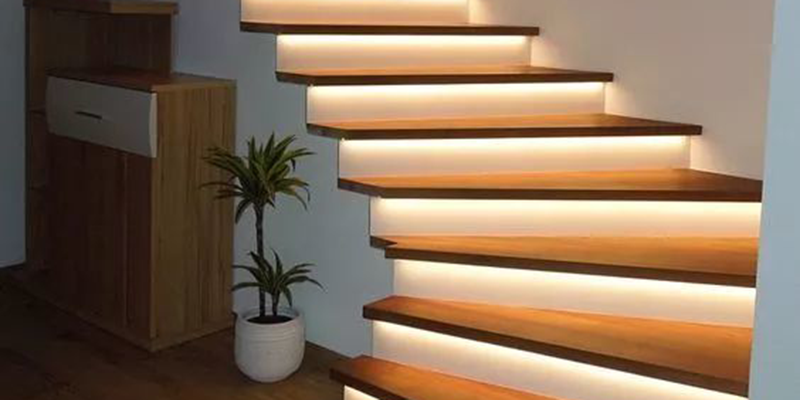 Staircase, lighting, interior LED strip lights illuminating modern wooden stairs in a home interior