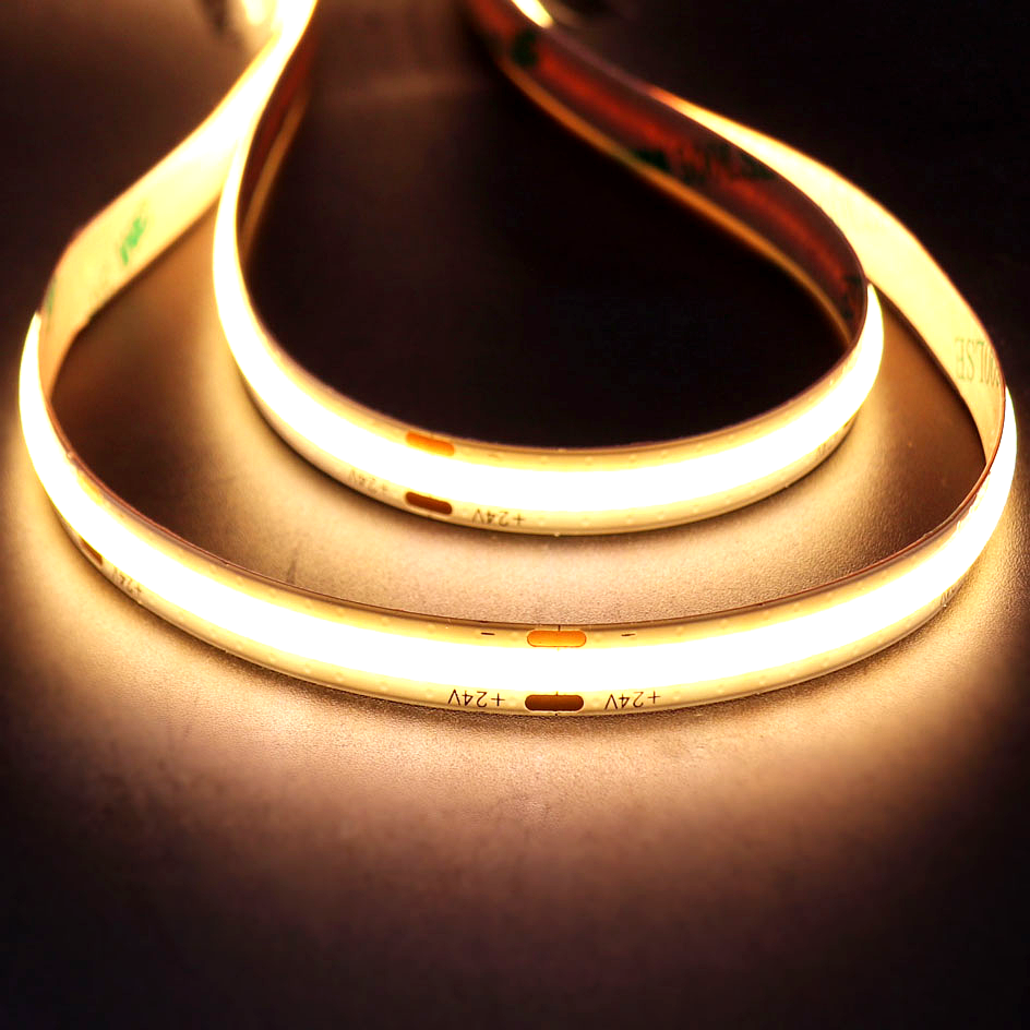 Close-up view of a glowing 24V COB flexible LED strip light, highlighting uniform illumination and bendable design for accent lighting