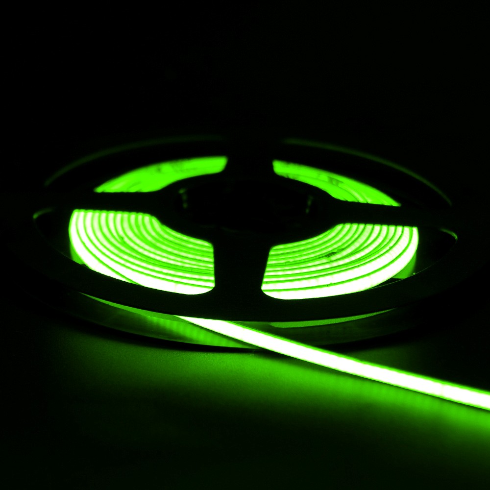 Glowing green neon flex LED strip light coiled on a reel, emitting vibrant light in a dark background, ideal for signage or ambient lighting.