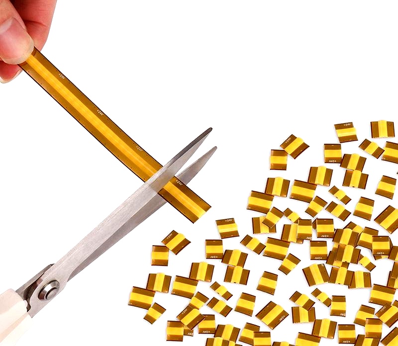 Hand cutting flexible LED strip insulation layer into pieces using scissors, showing customization and easy processing for lighting applications