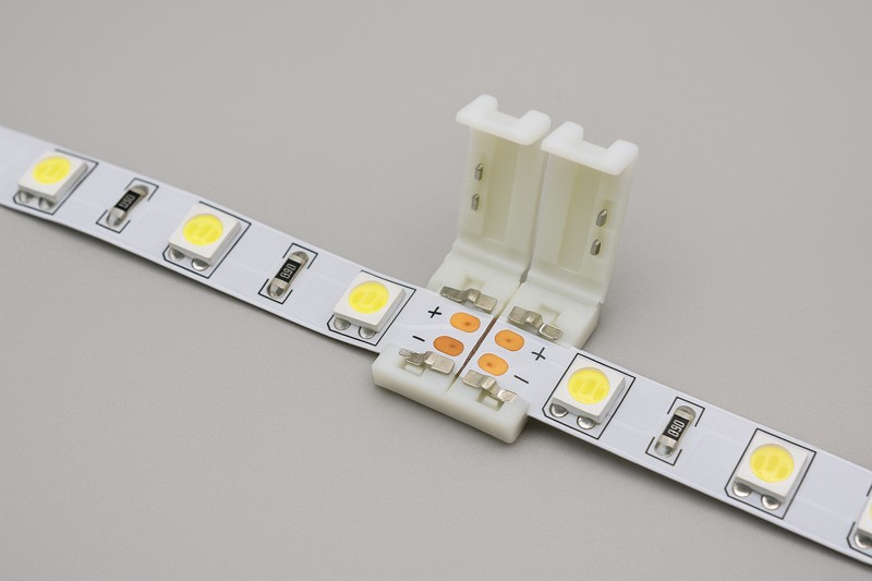Solderless LED strip connector joining two cut pieces of LED strip light