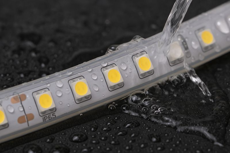 A shot of an IP65 strip with a silicone coating being lightly splashed with water, showing the water beading up on the surface.